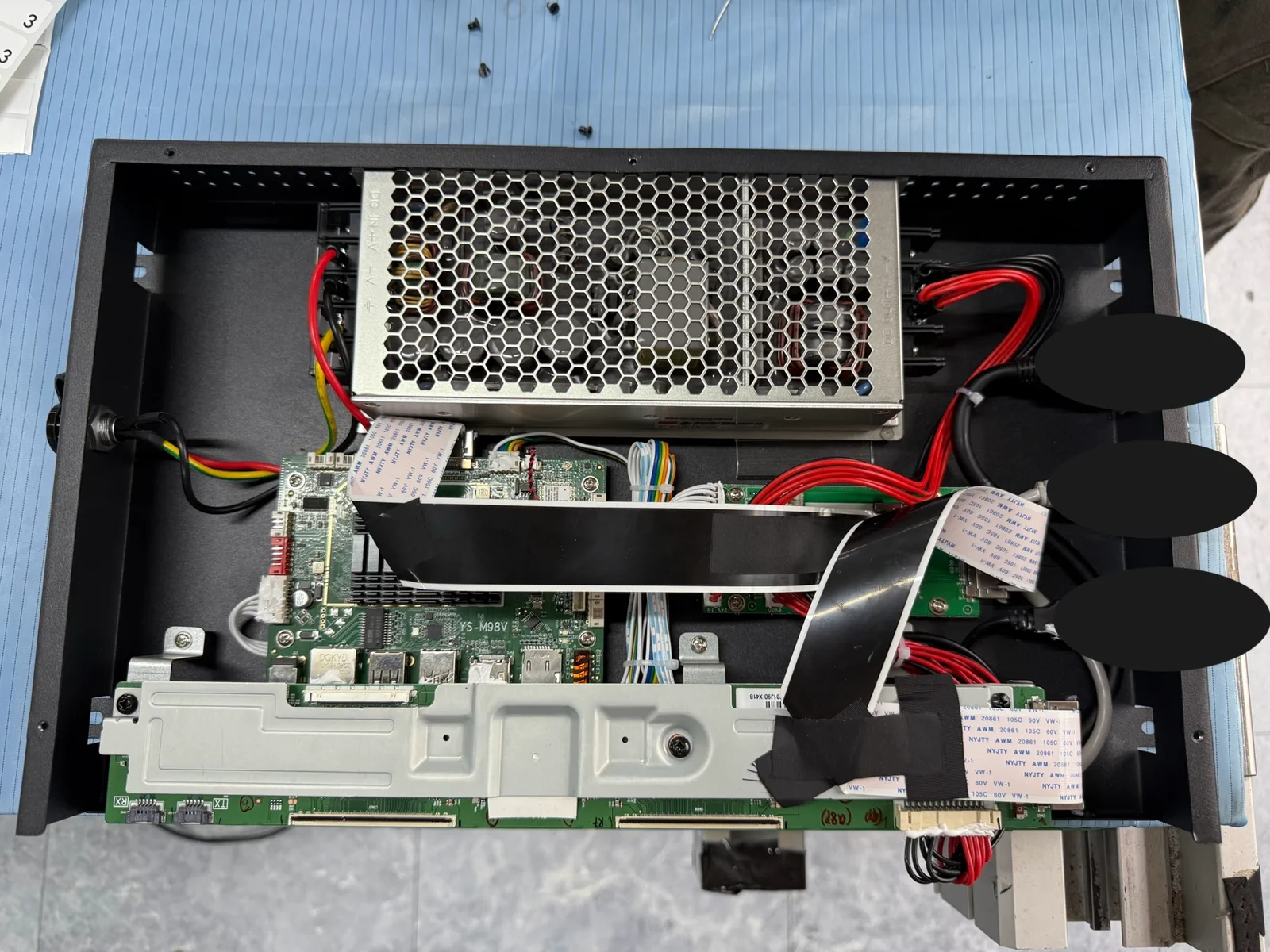 Open display enclosure showing the controller board, power supply, signal cables and service connections