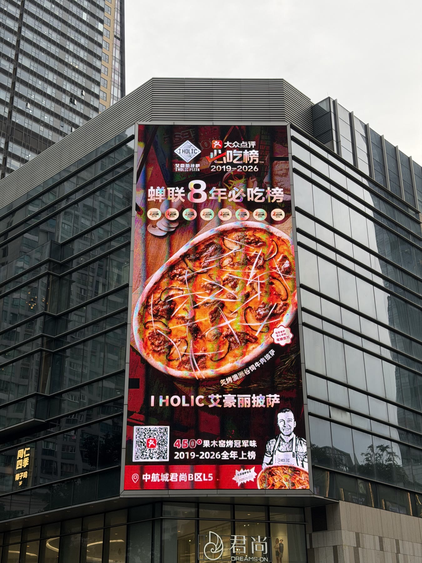 Street-corner LED media facade integrated into a multi-storey retail building